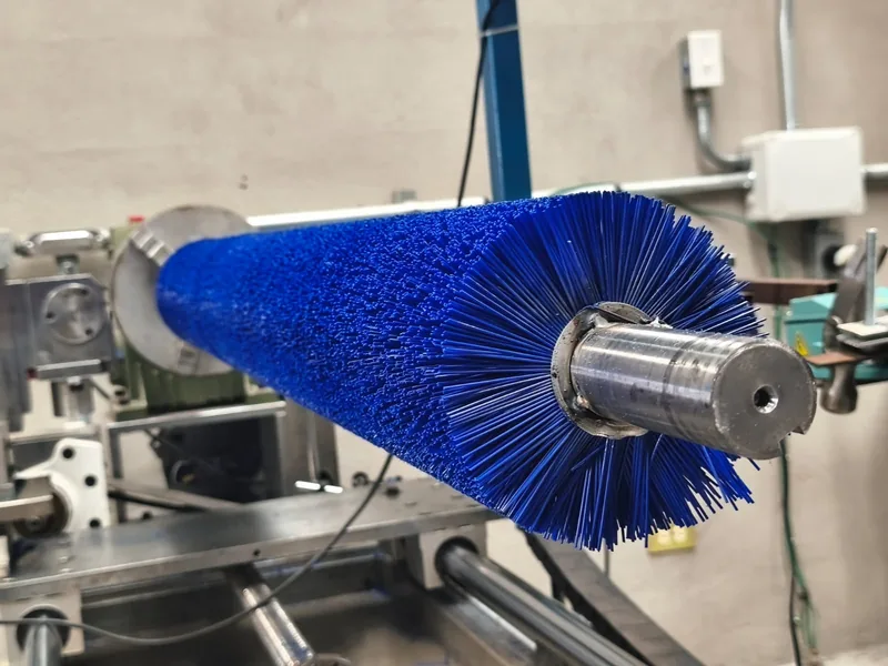 Blue industrial roller brush for conveyor cleaning and material handling